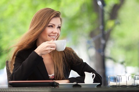 Brunette drinking coffee outdoor cafe
